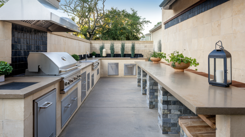 a photo of a long outdoor kitchen layout with a sleek concrete counter top